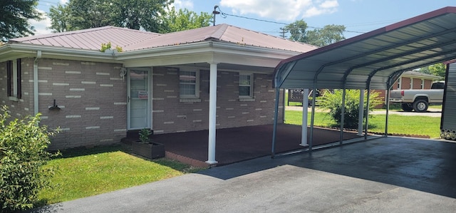 205 Galen Rd, Lafayette, TN 37083 - view of front of house with brick siding, driveway, a front yard, a metal roof, and a detached carport