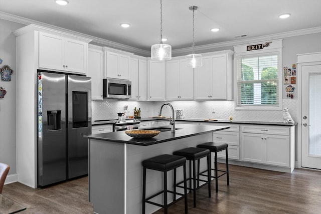 5086 Oop Rd, Chattanooga, TN 37416 - kitchen featuring stainless steel appliances, dark countertops, dark wood-style flooring, a breakfast bar, and crown molding