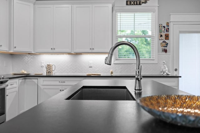 5086 Oop Rd, Chattanooga, TN 37416 - kitchen with dark countertops, backsplash, and white cabinetry