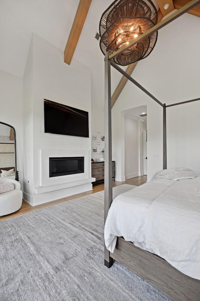 4720 Edwardian Trce, Franklin, TN 37067 - bedroom with beamed ceiling, high vaulted ceiling, a glass covered fireplace, and wood finished floors