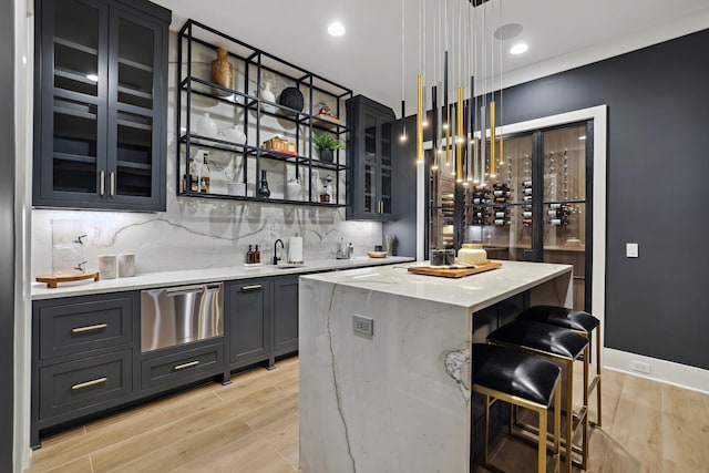 4720 Edwardian Trce, Franklin, TN 37067 - indoor wet bar with light wood-style flooring, tasteful backsplash, a warming drawer, stainless steel dishwasher, and pendant lighting