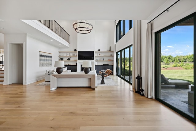 4720 Edwardian Trce, Franklin, TN 37067 - living room featuring a towering ceiling, stairway, light wood finished floors, and a chandelier