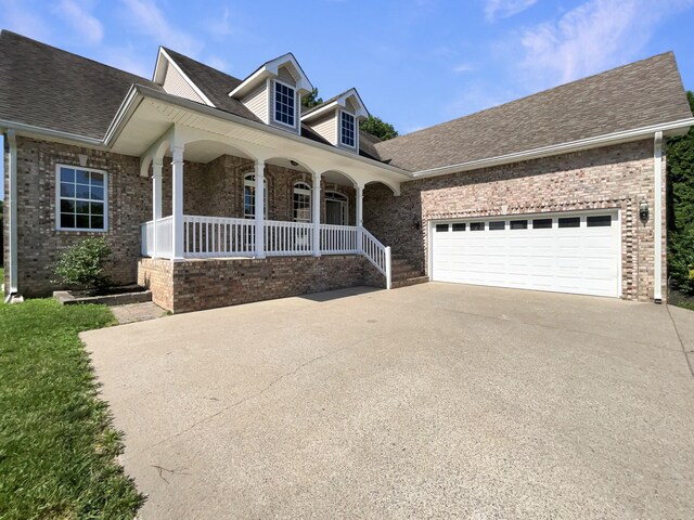 3624 Prestwicke Pl, Adams, TN 37010 - view of front of home with covered porch, concrete driveway, brick siding, a shingled roof, and an attached garage