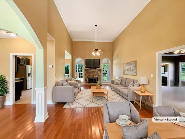 3624 Prestwicke Pl, Adams, TN 37010 - living room with a towering ceiling, ceiling fan, light wood-type flooring, ornamental molding, and a stone fireplace