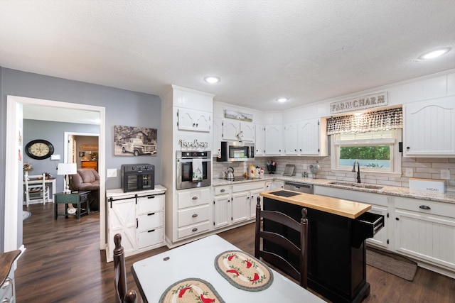 106 Mcfarlin Rd, Murfreesboro, TN 37130 - kitchen with appliances with stainless steel finishes, backsplash, dark wood finished floors, white cabinets, and recessed lighting
