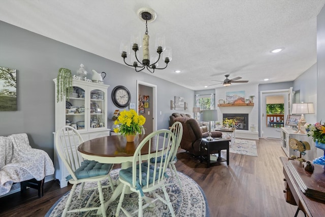 106 Mcfarlin Rd, Murfreesboro, TN 37130 - dining space featuring ceiling fan, a chandelier, wood finished floors, a textured ceiling, and a glass covered fireplace