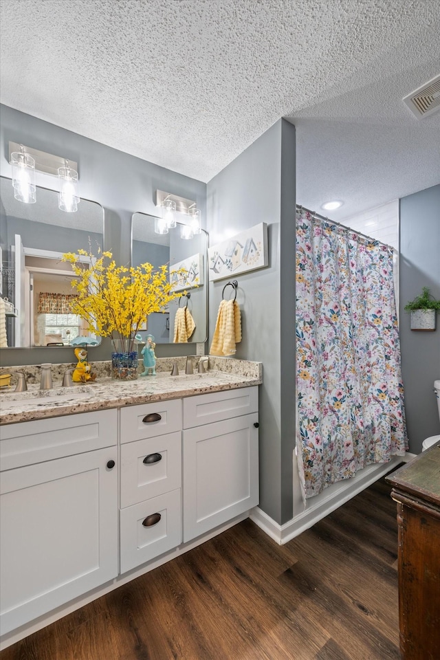 106 Mcfarlin Rd, Murfreesboro, TN 37130 - bathroom featuring double vanity, a textured ceiling, wood finished floors, and a shower with curtain