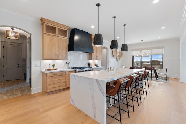 2996 S Rutland Rd, Mount Juliet, TN 37122 - kitchen featuring custom range hood, arched walkways, light wood-style floors, a large island with sink, and a kitchen breakfast bar