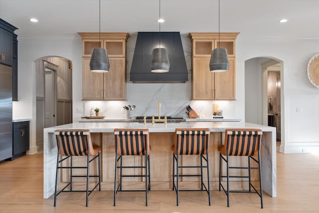 2996 S Rutland Rd, Mount Juliet, TN 37122 - kitchen with exhaust hood, arched walkways, light countertops, crown molding, and tasteful backsplash