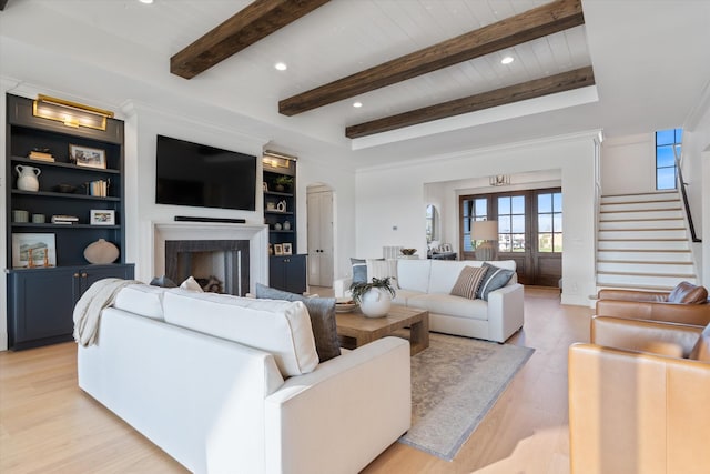2996 S Rutland Rd, Mount Juliet, TN 37122 - living area with light wood-style flooring, a fireplace, stairway, arched walkways, and beamed ceiling