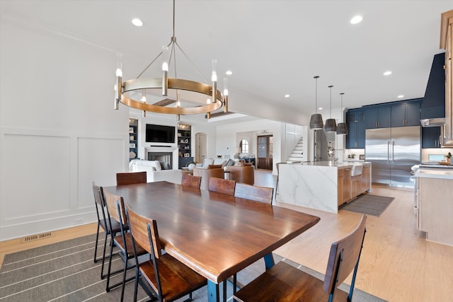 2996 S Rutland Rd, Mount Juliet, TN 37122 - dining room with a decorative wall, light wood finished floors, a chandelier, stairway, and recessed lighting