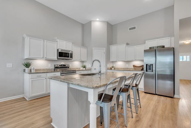 272 Thorpe Dr, Spring Hill, TN 37174 - kitchen featuring stainless steel appliances, a towering ceiling, light wood-style flooring, and white cabinetry