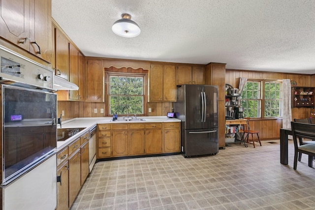 2604 Forest View Dr, Antioch, TN 37013 - kitchen with appliances with stainless steel finishes, a textured ceiling, healthy amount of natural light, brown cabinets, and light countertops