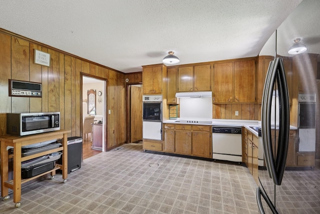 2604 Forest View Dr, Antioch, TN 37013 - kitchen with black appliances, light floors, brown cabinetry, light countertops, and wooden walls