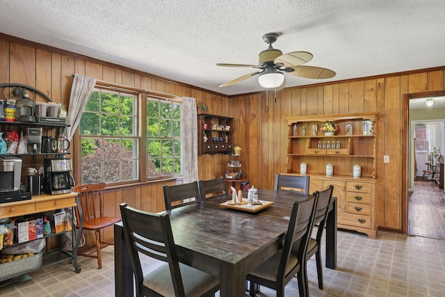 2604 Forest View Dr, Antioch, TN 37013 - dining area featuring wooden walls, a textured ceiling, a ceiling fan, crown molding, and light floors