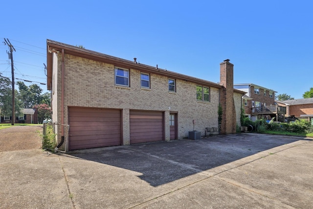 2604 Forest View Dr, Antioch, TN 37013 - rear view of house featuring an attached garage, concrete driveway, brick siding, and a chimney