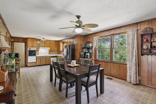2604 Forest View Dr, Antioch, TN 37013 - dining area with wooden walls, ceiling fan, light flooring, a textured ceiling, and ornamental molding