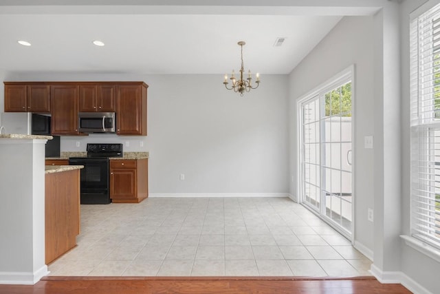 446 Lazy Creek Ln, Nashville, TN 37211 - kitchen featuring black electric range, stainless steel microwave, a chandelier, freestanding refrigerator, and light stone counters