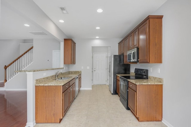 446 Lazy Creek Ln, Nashville, TN 37211 - kitchen featuring appliances with stainless steel finishes, light stone countertops, recessed lighting, a peninsula, and brown cabinets
