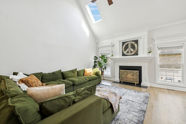 2819 Silver Springs Ct, Murfreesboro, TN 37128 - living room featuring a fireplace with flush hearth, wood finished floors, ceiling fan, a skylight, and crown molding