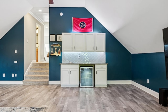 2819 Silver Springs Ct, Murfreesboro, TN 37128 - indoor bar featuring wine cooler, light wood-type flooring, vaulted ceiling, decorative backsplash, and stairs