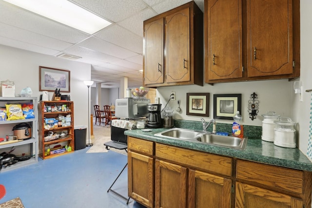 311 Downs Rd, Cumberland City, TN 37050 - kitchen featuring a drop ceiling, brown cabinets, and dark countertops