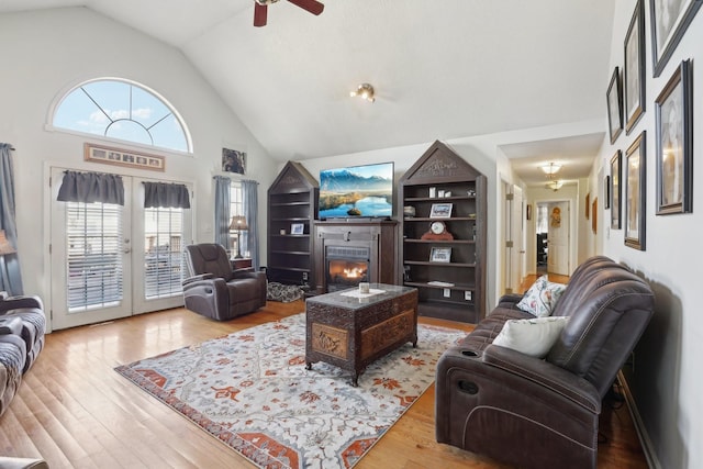 311 Downs Rd, Cumberland City, TN 37050 - living room with high vaulted ceiling, a ceiling fan, wood finished floors, and a glass covered fireplace