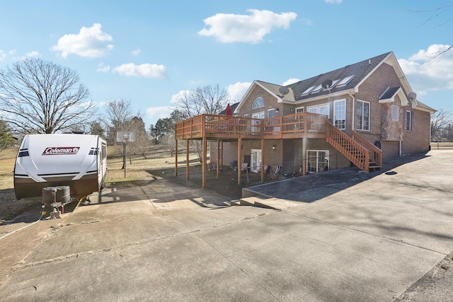 311 Downs Rd, Cumberland City, TN 37050 - rear view of property featuring a wooden deck, driveway, brick siding, and stairs