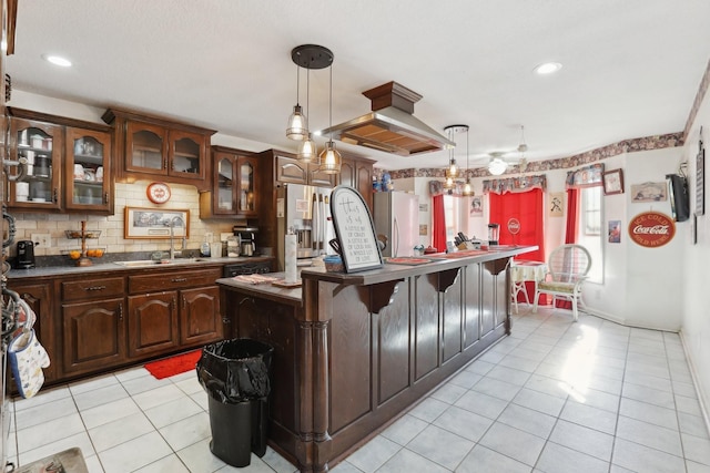 311 Downs Rd, Cumberland City, TN 37050 - kitchen with light tile patterned flooring, refrigerator, dark countertops, island range hood, and backsplash