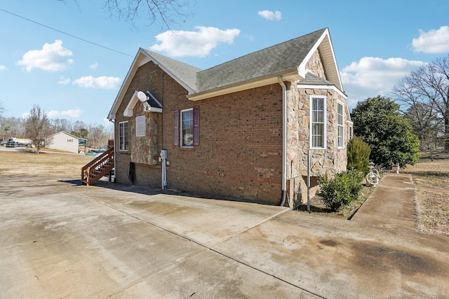 311 Downs Rd, Cumberland City, TN 37050 - view of side of home featuring roof with shingles, stone siding, and brick siding