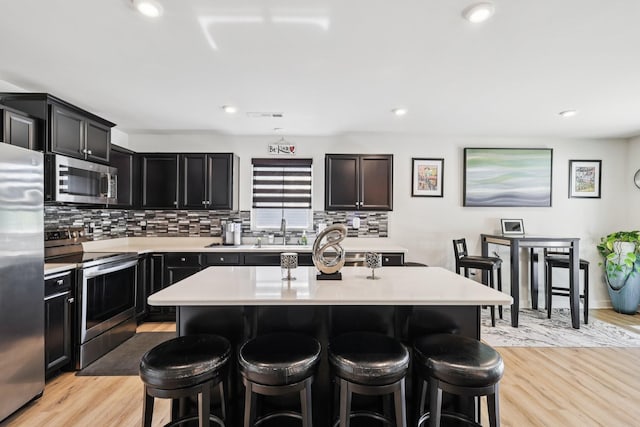 2617 Thornton Grove Blvd, Nashville, TN 37207 - kitchen with stainless steel appliances, a kitchen breakfast bar, backsplash, light countertops, and light wood-style flooring