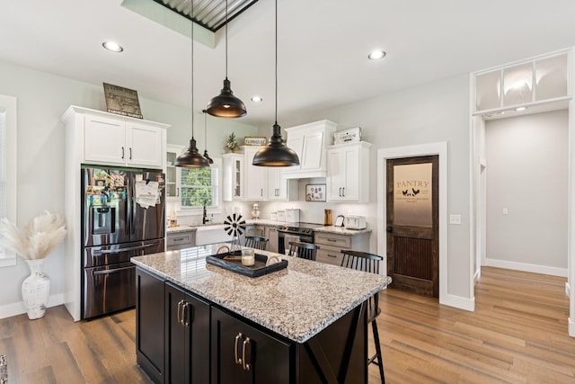 2427 Green Valley Rd, Lafayette, TN 37083 - kitchen with stainless steel appliances, light wood-type flooring, white cabinets, a center island, and recessed lighting