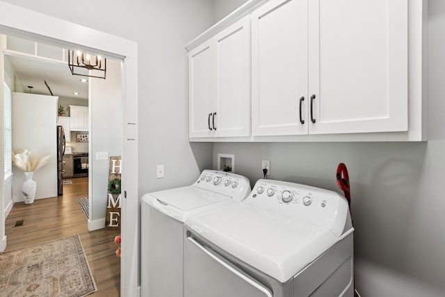 2427 Green Valley Rd, Lafayette, TN 37083 - laundry room featuring cabinet space, washer and clothes dryer, wood finished floors, and a chandelier