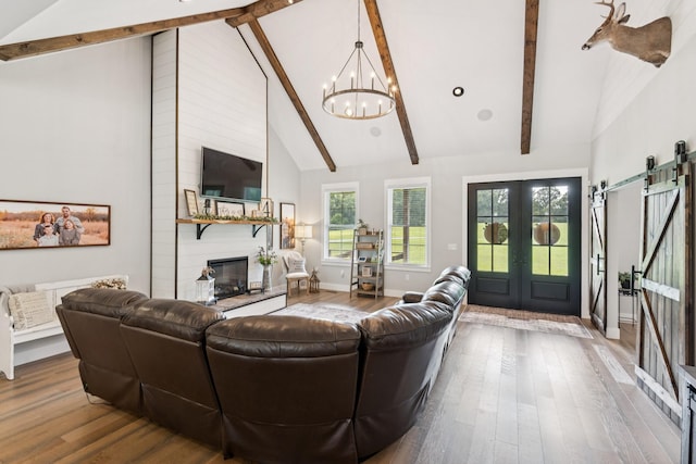 2427 Green Valley Rd, Lafayette, TN 37083 - living room featuring a chandelier, beamed ceiling, a barn door, wood finished floors, and a fireplace