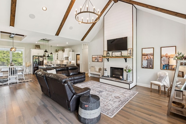 2427 Green Valley Rd, Lafayette, TN 37083 - living area featuring a chandelier, high vaulted ceiling, beam ceiling, dark wood-style floors, and a large fireplace
