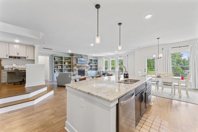 1150 Brixworth Dr, Spring Hill, TN 37174 - kitchen featuring dishwasher, light wood-type flooring, a fireplace, hanging light fixtures, and recessed lighting
