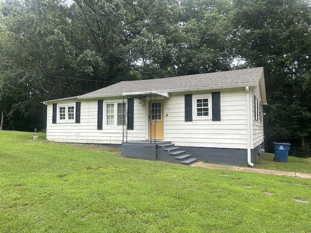 273 E Lake St, Camden, TN 38320 - view of front of house featuring a front lawn, roof with shingles, and view of wooded area