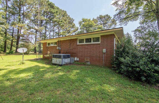 867 Lexington Hwy, Loretto, TN 38469 - rear view of house featuring a yard and brick siding