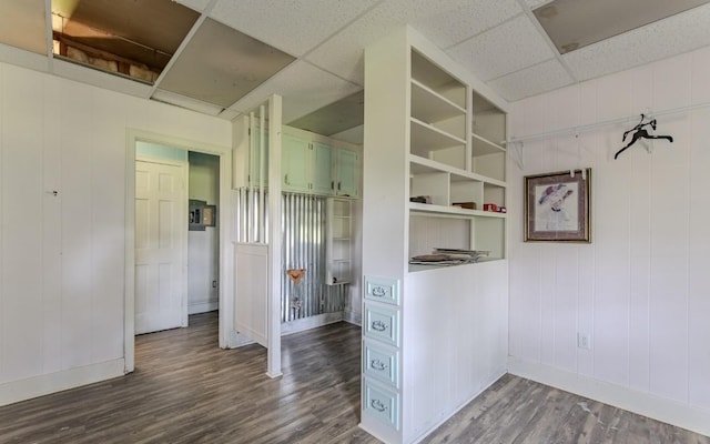 867 Lexington Hwy, Loretto, TN 38469 - unfurnished bedroom featuring dark wood-style floors, a paneled ceiling, and a decorative wall