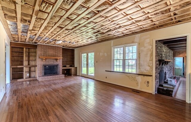 867 Lexington Hwy, Loretto, TN 38469 - unfurnished living room with a brick fireplace, built in features, and hardwood / wood-style floors