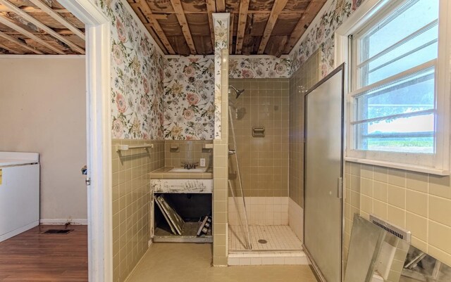 867 Lexington Hwy, Loretto, TN 38469 - bathroom with tile walls, wallpapered walls, a stall shower, wainscoting, and wood finished floors