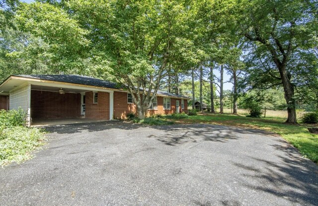 867 Lexington Hwy, Loretto, TN 38469 - view of front facade with driveway, brick siding, and an attached carport
