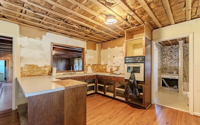 867 Lexington Hwy, Loretto, TN 38469 - kitchen with white oven, a peninsula, light wood-style flooring, and light countertops