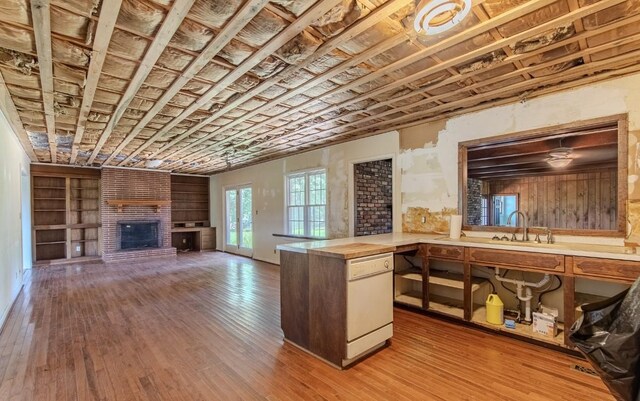 867 Lexington Hwy, Loretto, TN 38469 - kitchen featuring a brick fireplace, hardwood / wood-style floors, open floor plan, and built in shelves