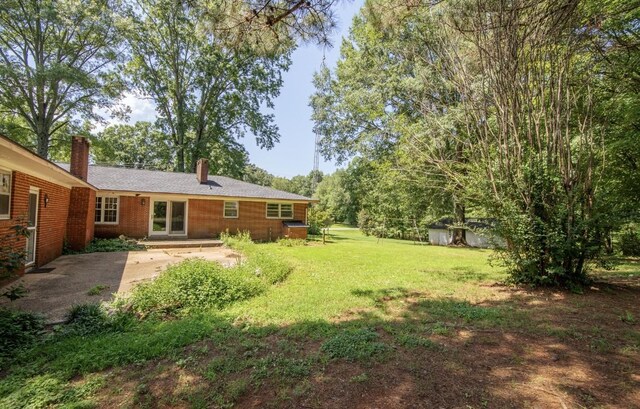 867 Lexington Hwy, Loretto, TN 38469 - view of green lawn featuring a patio area and an outbuilding