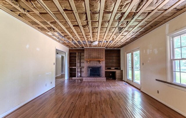 867 Lexington Hwy, Loretto, TN 38469 - unfurnished living room featuring built in features, hardwood / wood-style floors, and a fireplace