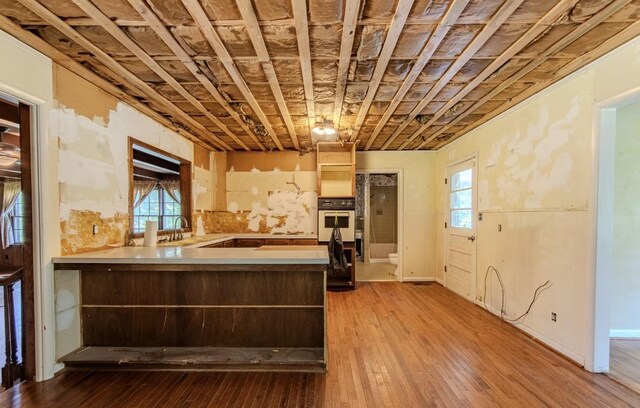 867 Lexington Hwy, Loretto, TN 38469 - kitchen featuring oven, a peninsula, hardwood / wood-style flooring, and healthy amount of natural light