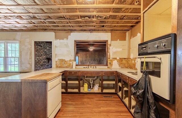 867 Lexington Hwy, Loretto, TN 38469 - kitchen featuring white appliances, light wood-style floors, and a peninsula