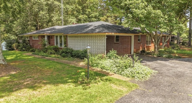 867 Lexington Hwy, Loretto, TN 38469 - view of front of home with asphalt driveway, brick siding, and a front yard