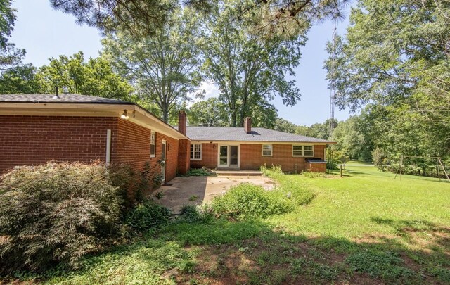 867 Lexington Hwy, Loretto, TN 38469 - rear view of house with a chimney, a patio area, a lawn, and brick siding